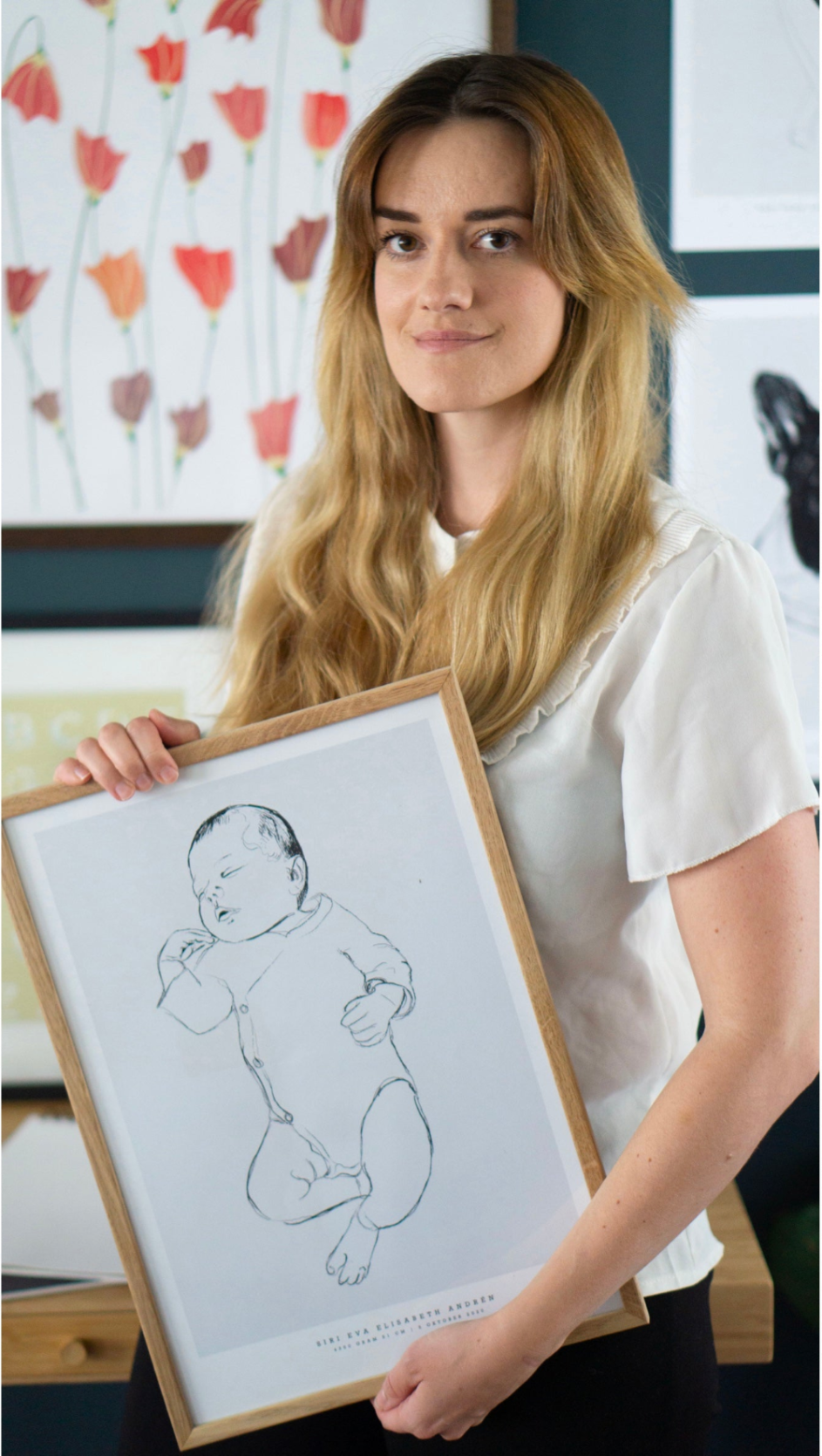 Person holding a hand-drawn personalized birth poster