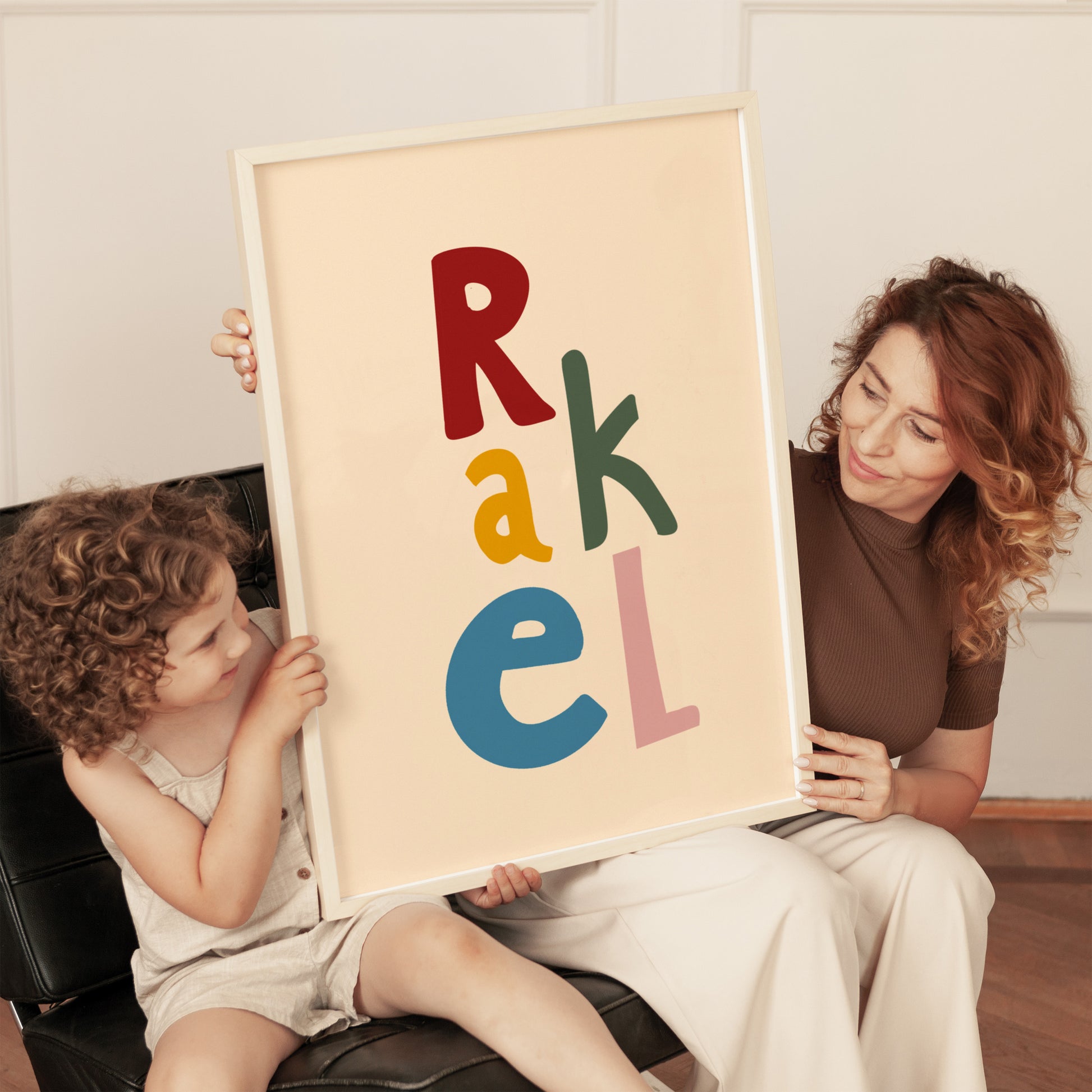 Mom and daughter holding a custom name poster for kids room, colorful and bold design personalized with the name Rakel, perfect for nursery or playroom wall decor.