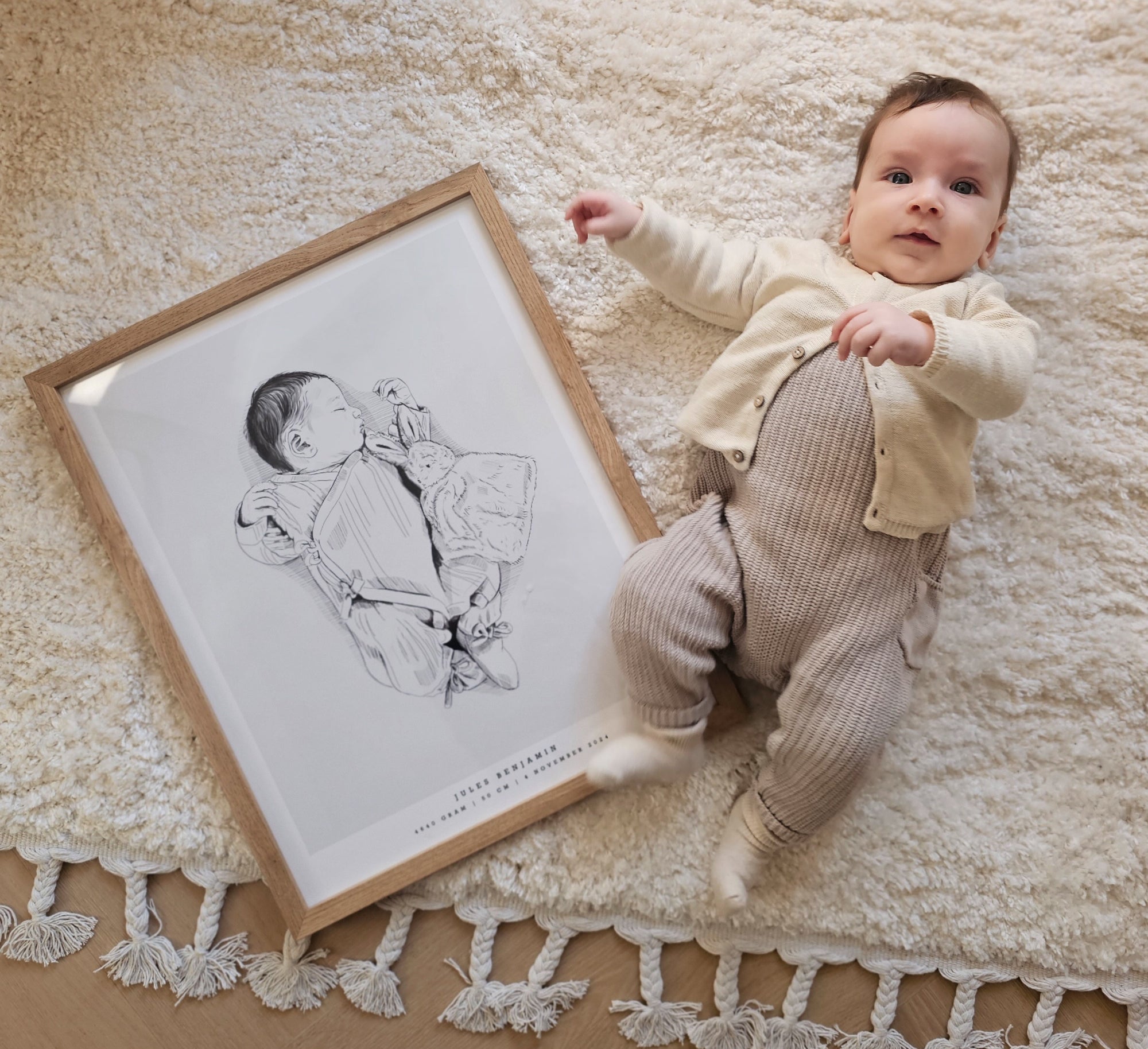 Newborn baby lying next to their custom hand-drawn birth poster