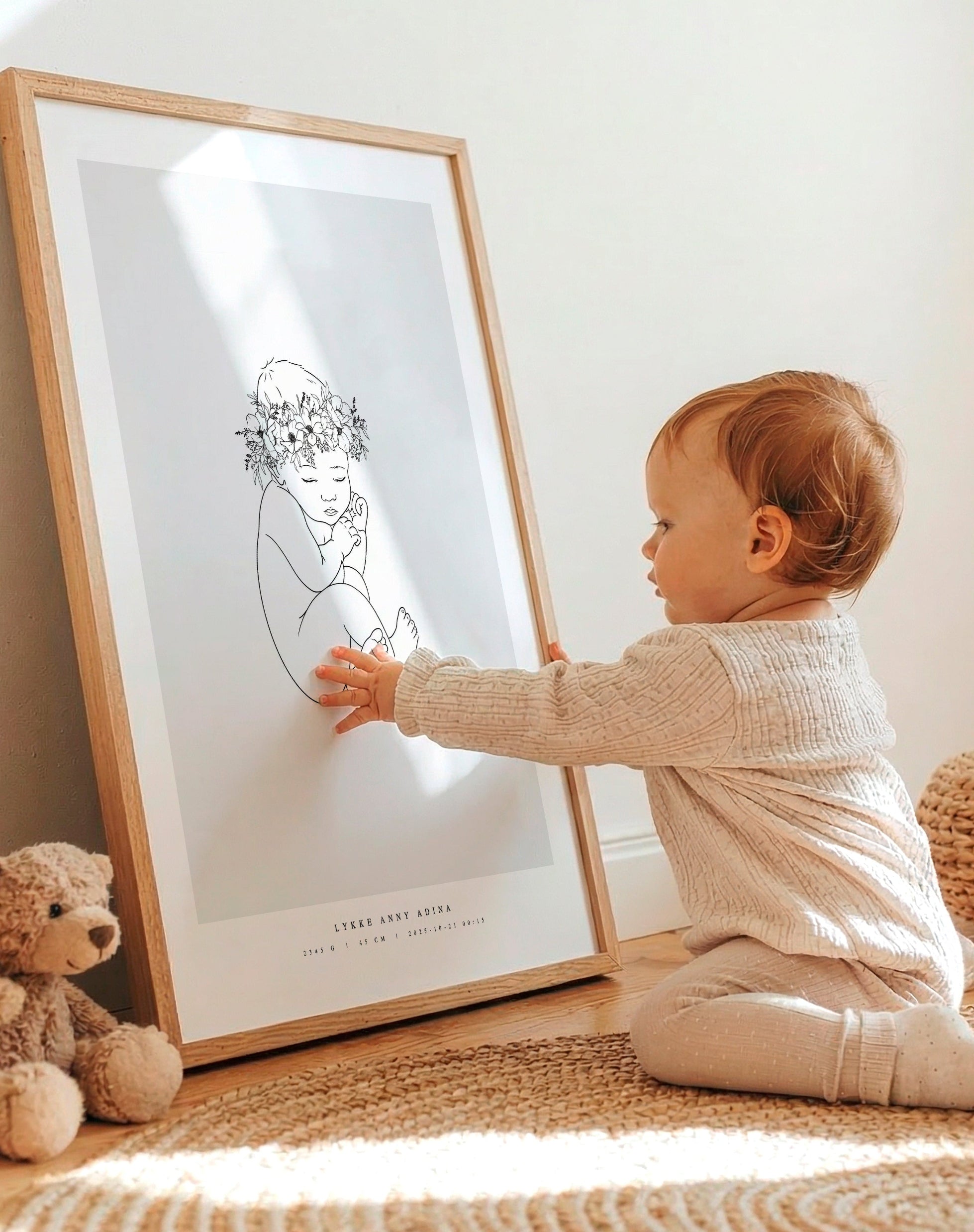 Småbarn som sitter vid sin födelsetavla i barnrummet. Toddler sitting next to their birth poster in the nursery.